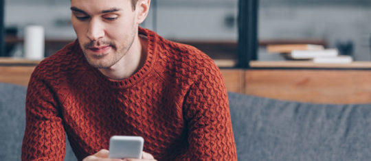 homme regarde son smartphone